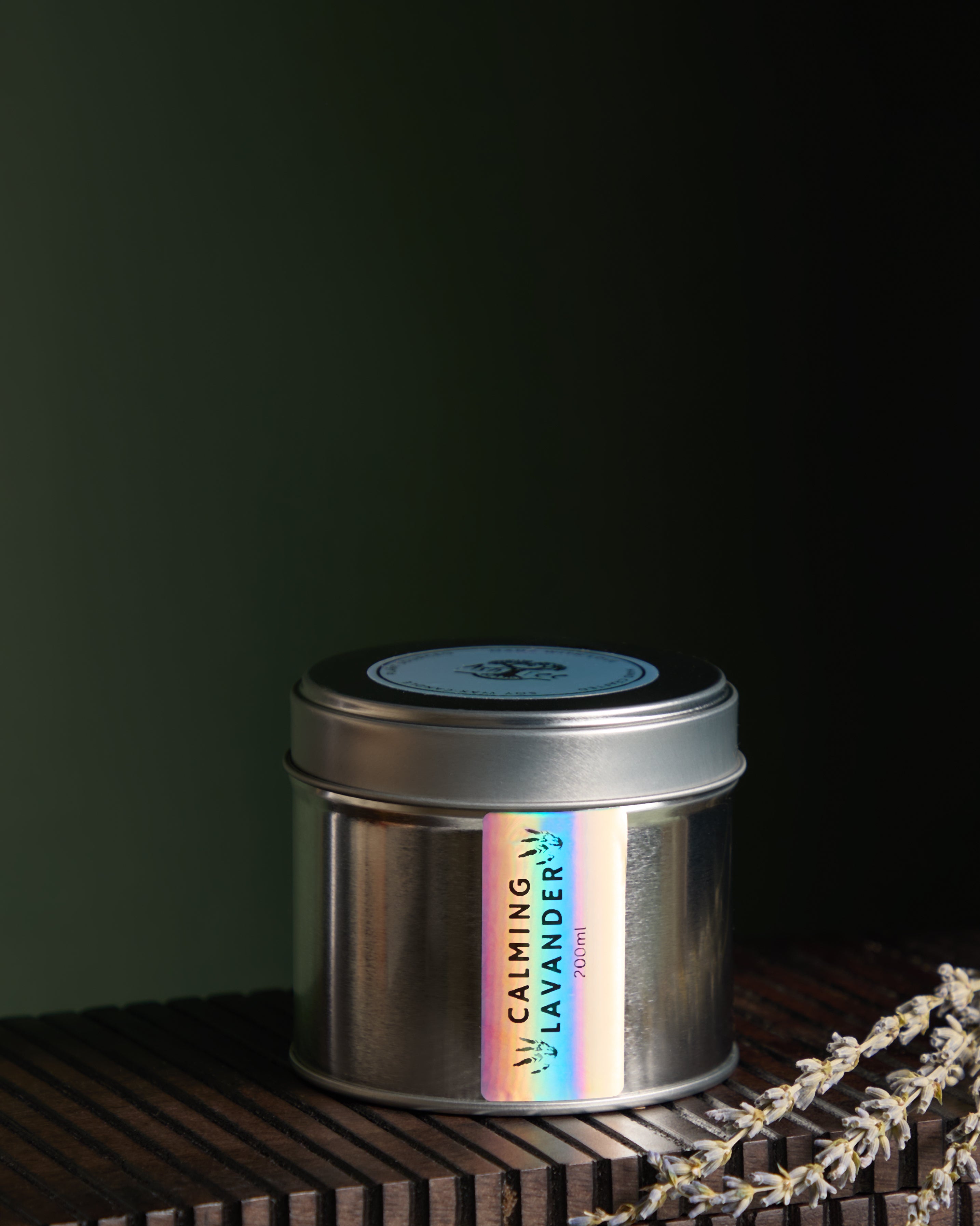Close up view of Luxury hand poured soy wax candle in a silver tin jar with natural soy wax colour and dried lavender petals on top, finished with holographic silver label.