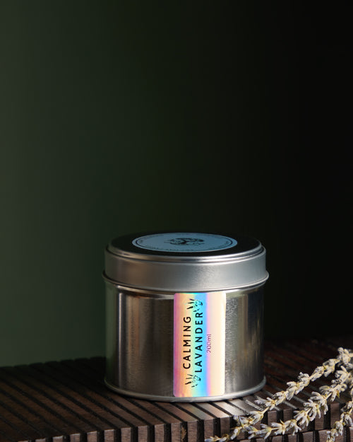 Close up view of Luxury hand poured soy wax candle in a silver tin jar with natural soy wax colour and dried lavender petals on top, finished with holographic silver label.