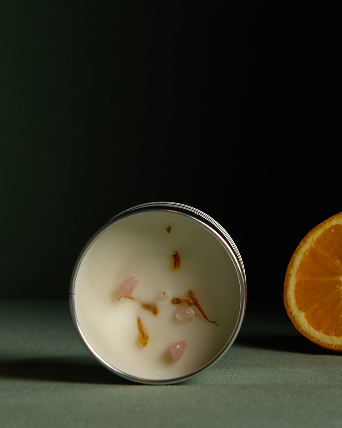 Candle with rose quartz crystals and marigold metals. Citric candle in silver tin container, from the brand Ash Tree Candles.