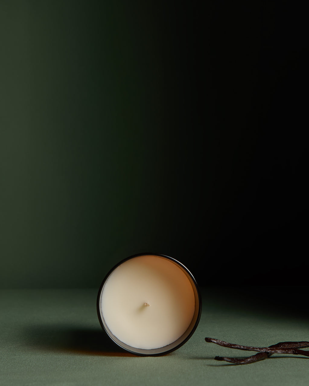 Close up view of Luxury hand poured soy wax candle with natural soy wax colour in an amber glass jar, wooden lid and fabric wick, finished with holographic silver label