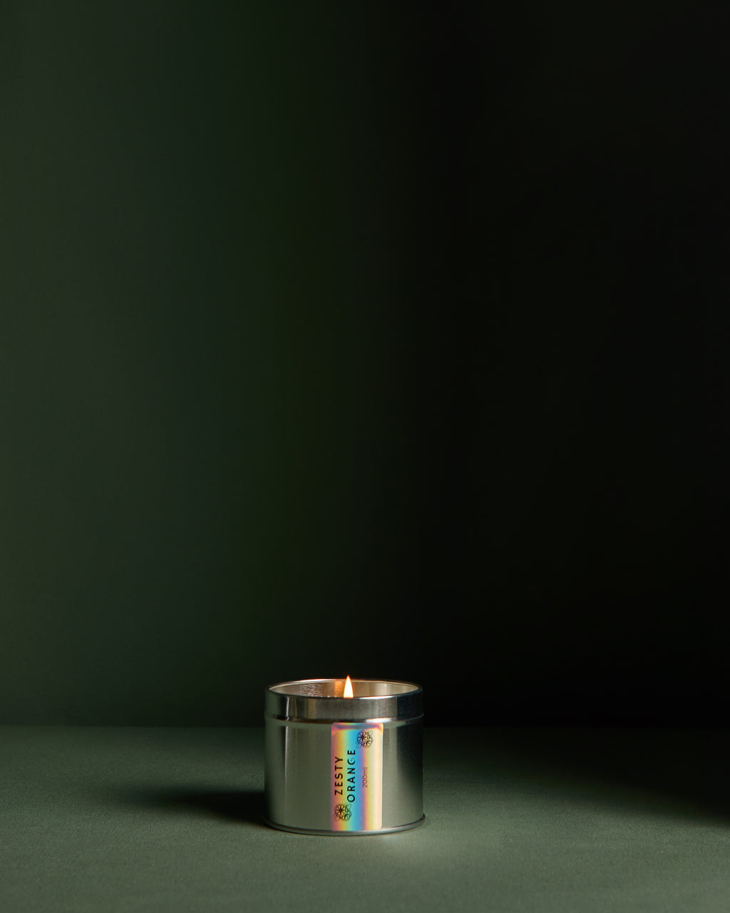 Side view of  Luxury hand poured soy wax candle in a silver tin jar with natural soy wax colour and dried lavender petals on top, finished with holographic silver label. Candle from the brand Ash Tree Candles.