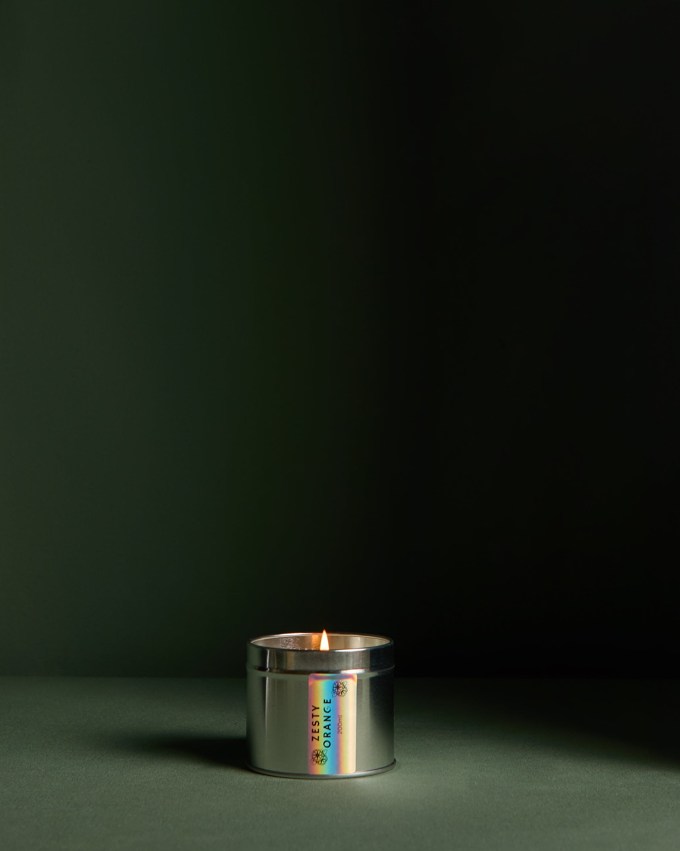 Side view of  Luxury hand poured soy wax candle in a silver tin jar with natural soy wax colour and dried lavender petals on top, finished with holographic silver label. Candle from the brand Ash Tree Candles.